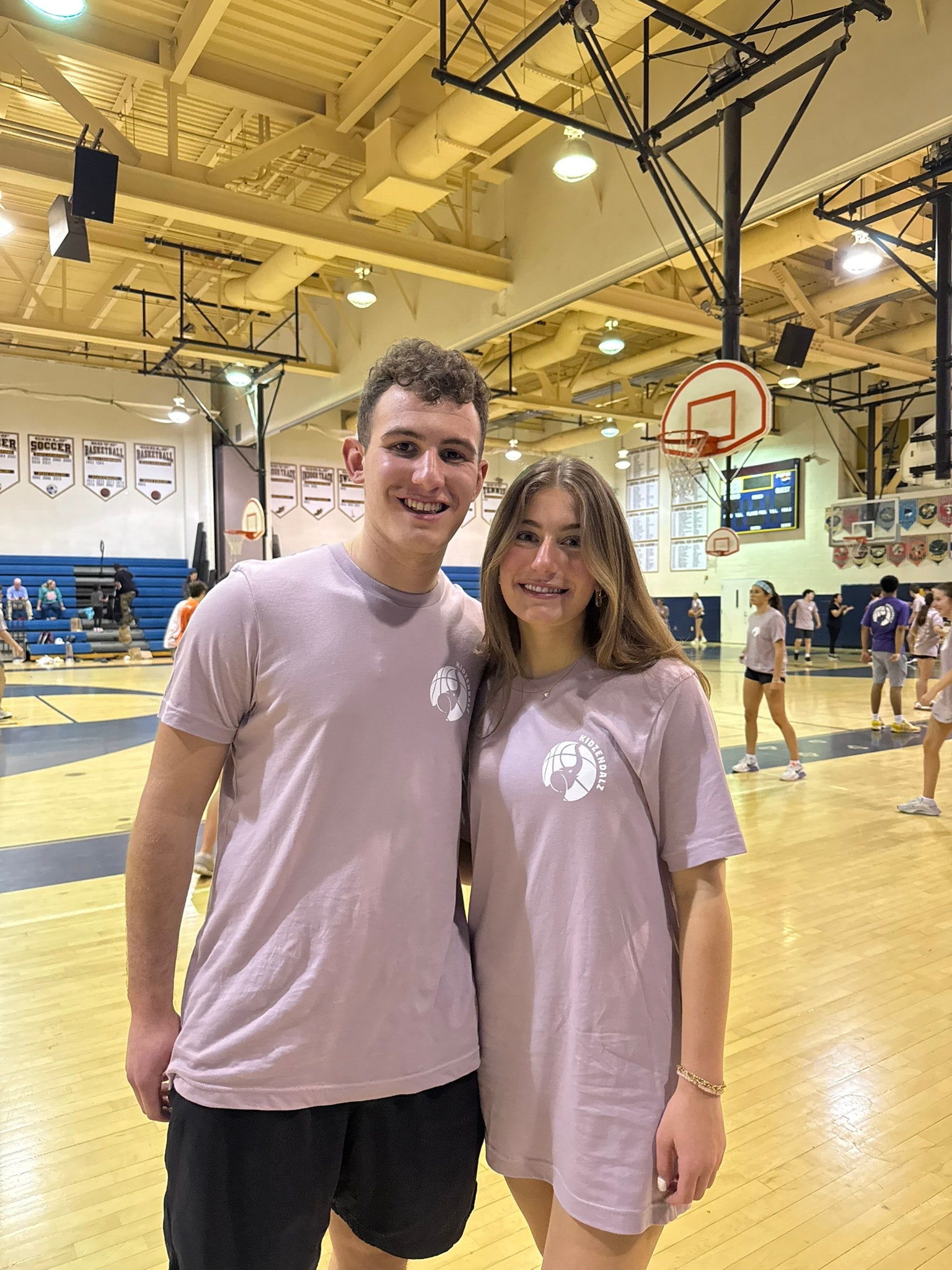KidzEndAlz founders smiling together on the basketball court at Dunk Alzheimer's
